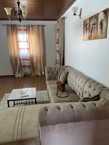 un soggiorno con un divano e un tavolo di Melvas home a Douala