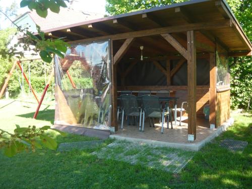 a pavilion with chairs and a table in a yard at Chalupa Erika in Dobšín