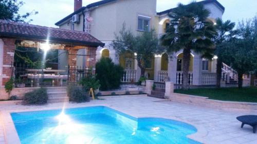 a house with a swimming pool in front of a house at Apartments Barbara in Poreč
