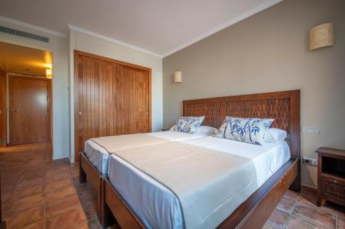 a bedroom with a large bed with a wooden headboard at Hotel La Grava in El Morell