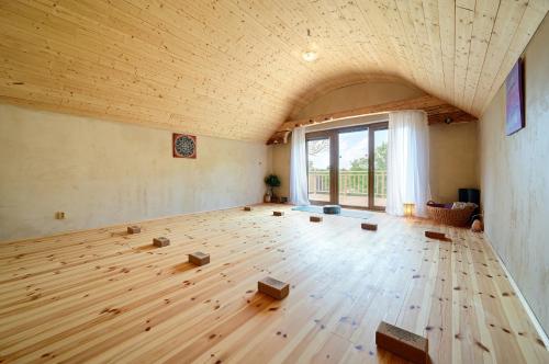 a large room with a wooden floor and a large window at Chalupa Ořešák - Walnut House in Svojšice