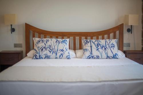 a bed with blue and white sheets and pillows at Hotel La Grava in El Morell