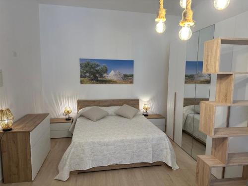 a white bedroom with a bed and two night stands at Terrazza Adriatica in Polignano a Mare