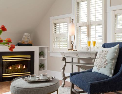a living room with a fireplace and a blue chair at White Doe Inn Bed & Breakfast in Manteo