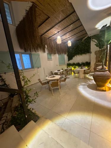 un patio con tavolo, sedie e un grande vaso di Luvenza Hotel Alaçatı a Çeşme