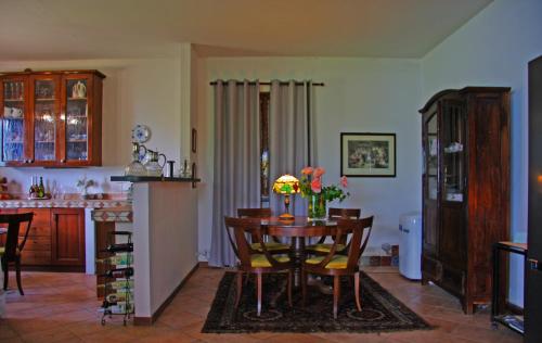 a kitchen and dining room with a table with flowers on it at Villa Grazie Mille - Charming Lake Como Escape in Perledo