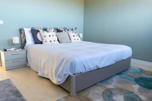 une chambre avec un grand lit avec des oreillers dessus dans l'établissement Favoloso appartamento vista panoramica mare e colline, à La Croix-Valmer