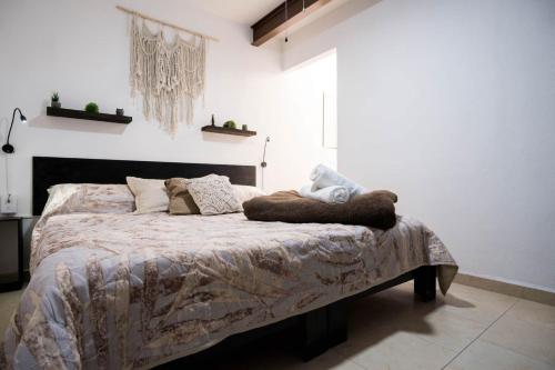 a bedroom with a bed with a blanket on it at Casa Dorada in León