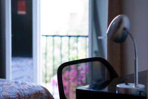 a desk with a lamp and a chair next to a window at Casa Dorada in León