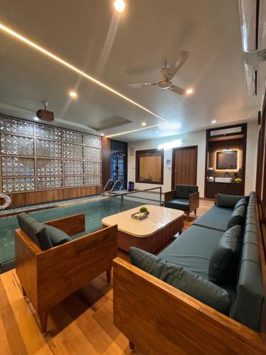 a living room with a pool and a couch and a table at The SkyStone Villa3BHKIndoorPool in Kālwāra