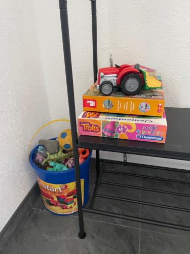 a table with a pile of books and a toy car on top at У Максима in Petrovac na Mlavi