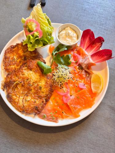 a plate of food with meat and vegetables on a table at Chambre double dans Auberge Alsacienne in Scherwiller