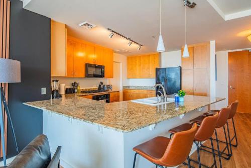a kitchen with a large island with bar stools at Stylish 1BR HighRise DT, Parking, Pool, Gym, W-D, Golf in Phoenix