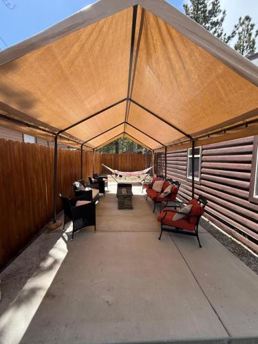 a tent with chairs and a hammock in it at Whispering Pines - Big Bear Lake in Big Bear Lake