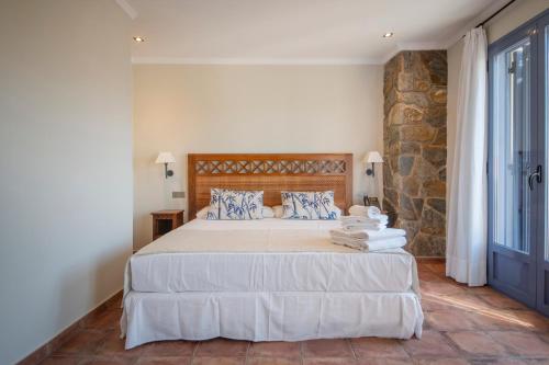 a bedroom with a large bed with towels on it at Hotel La Grava in El Morell