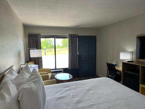 a hotel room with a bed and a desk at Days Inn by Wyndham Branson Ozarks in Branson