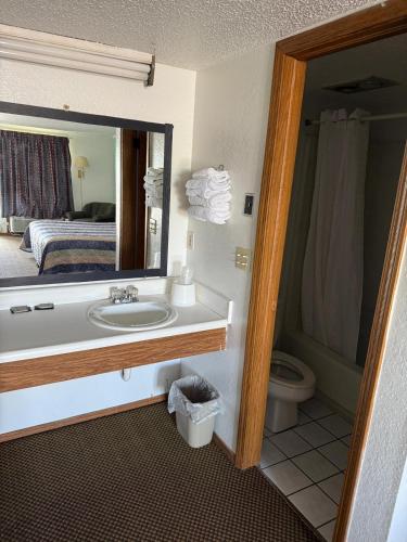 a bathroom with a sink and a toilet and a mirror at Royal Inn in Oklahoma City