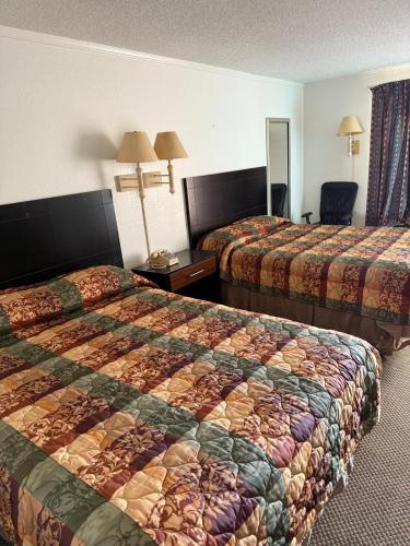a hotel room with two beds and a mirror at Royal Inn in Oklahoma City