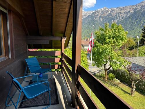a pair of chairs on the porch of a house at Chalet Rose - Einfamilienhaus in Interlaken