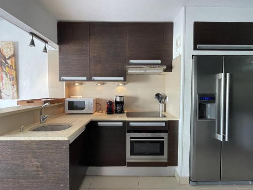 une cuisine avec un réfrigérateur en acier inoxydable et un évier dans l'établissement Villa ACAPULCO - Port Nature VPN61 - Luxe - 4 personnes, au Cap d'Agde