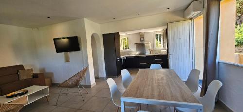 a living room with a table and a kitchen at T3 Dolce & Vita A3 avec Piscine et vue Montagnes in Propriano