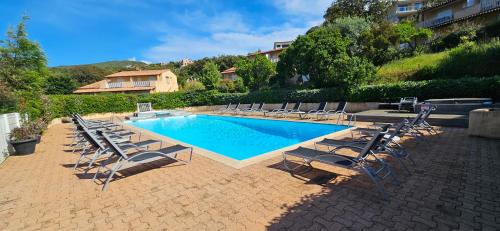a group of chairs and a swimming pool at T3 Dolce & Vita A3 avec Piscine et vue Montagnes in Propriano