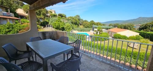 d'une table bleue et de chaises sur un balcon avec vue. dans l'établissement T3 Dolce & Vita A3 avec Piscine et vue Montagnes, à Propriano