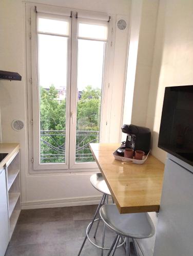 une cuisine avec une table et deux chaises ainsi qu'une fenêtre dans l'établissement Studio cosy - proche Metro13 G Péri, à Gennevilliers
