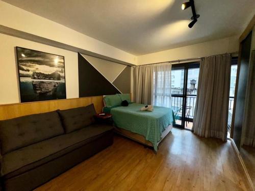 a living room with a couch and a bed at Studio I Bela Vista – 5min. do Metrô Liberdade in Sao Paulo