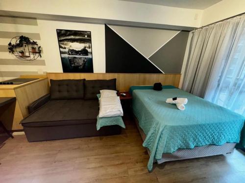a bed and a couch in a room at Studio I Bela Vista – 5min. do Metrô Liberdade in Sao Paulo