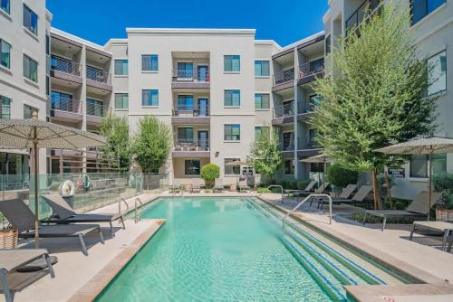 a swimming pool with chairs and a building at Serene 1BR Uptown Biltmore Gym Pool Parking WD in Phoenix