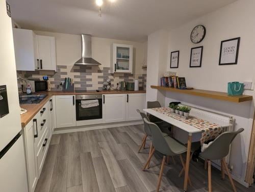 eine Küche mit einem Tisch, Stühlen und einer Theke in der Unterkunft Family house near the beach! in Saint Columb Minor