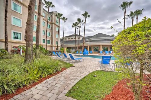 a hotel with blue chairs and a swimming pool at Lake Buenavista Apartments close to Disney in Orlando