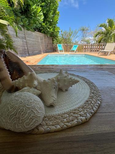 een schelpenbeeld naast een zwembad bij Villa Soualiga Orient Bay 150 m de la plage in Orient Bay