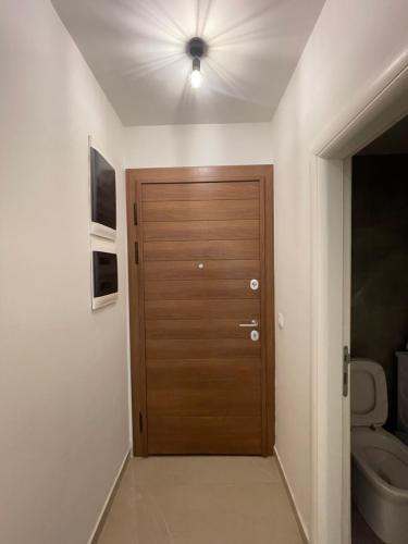 a bathroom with a wooden door and a toilet at The Home Away From Home 3 in Skopje