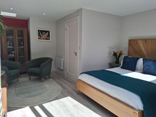 a bedroom with a bed and a desk and a chair at Granville House Apartments and Garden Suites in Ballyferriter