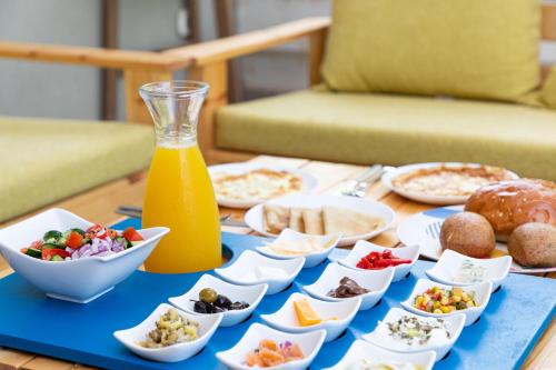 einen Tisch mit Teller mit Lebensmitteln und einer Flasche Orangensaft in der Unterkunft Bednesher Vacation Apartment for Families in Ma'ale Gamla