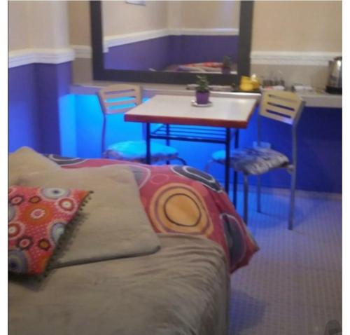 a room with a couch and a table with chairs at Hospedaje in La Plata