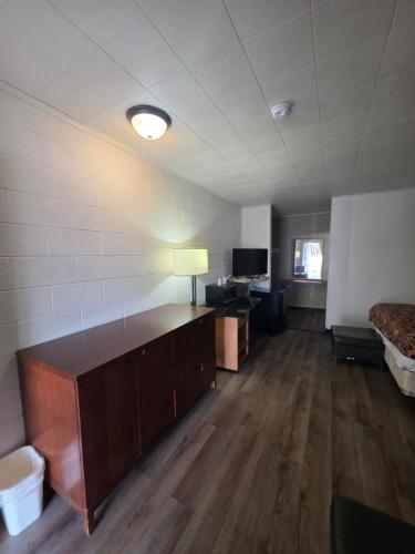 an empty room with a desk and a bed and a television at Stardust inn in El Dorado