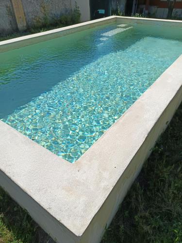 a swimming pool with blue water in a yard at Casa das Laranjeiras e parque infantil in Villa Nogueira