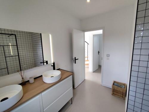 une salle de bain blanche avec deux lavabos et un miroir dans l'établissement Le Pélican By Nid'Ouest, à Plovan
