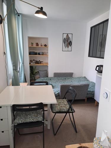 Cette chambre comprend un bureau, des chaises et un lit. dans l'établissement Studio du BoisDHyver, à Fontainebleau