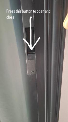 a refrigerator with a button to open and close at By The Way Apartment 1 in Larnaka