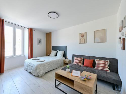 a living room with a bed and a couch at L'Adresse tranquille Douceur et Discrétion in Cholet