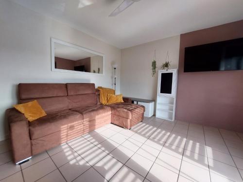 un salon avec un canapé marron et une table dans l'établissement Le Cosy Gaillard - Meublé Tourisme 3 Etoiles, à Brive-la-Gaillarde