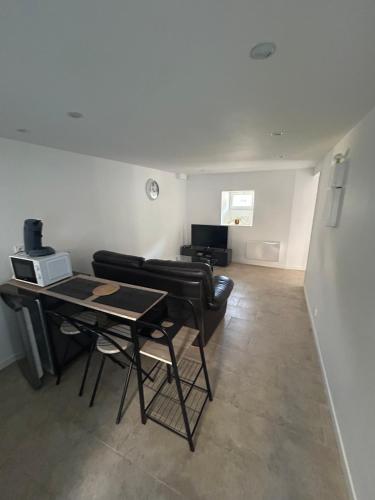 un salon avec une table et un canapé dans l'établissement Appartement spacieux avec terrasse, Saint-Malo, Dinard, Dinan et Dol, à Miniac-Morvan