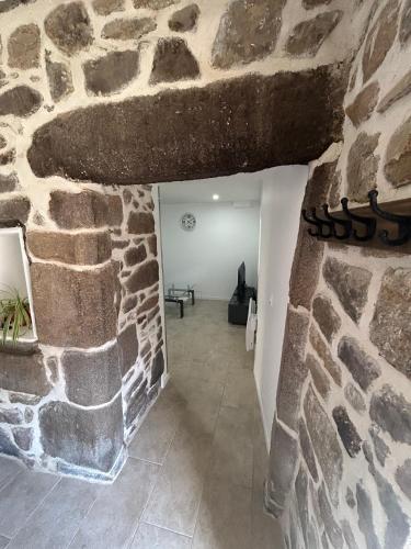 une pièce avec un mur en pierre et un couloir en pierre dans l'établissement Appartement spacieux avec terrasse, Saint-Malo, Dinard, Dinan et Dol, à Miniac-Morvan
