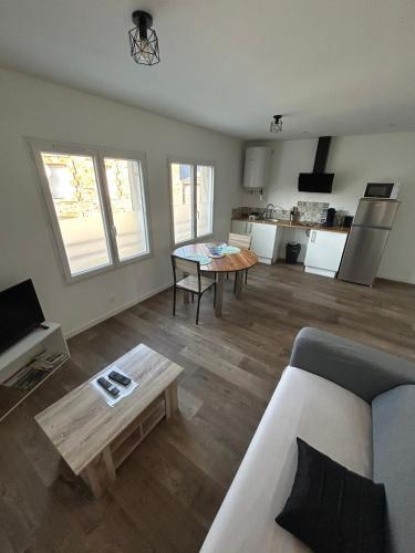 un salon avec un canapé et une table dans l'établissement Appartement T2 Saint Malo, Dinard, Dinan et Dol, à Miniac-Morvan