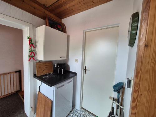 a small kitchen with a counter and a white refrigerator at Ferienwohnung am See in Königs Wusterhausen