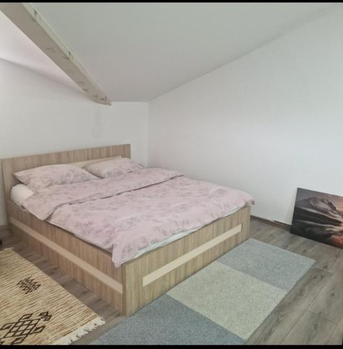 a bedroom with a bed in a white room at Square Apartment in Paraćin